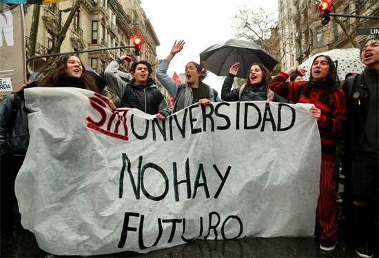 מפגינים מחזיקים בשלט שבו כתוב "אין עתיד בלי אוניברסיטאות" בהפגנה בחמישי / צילום: רויטרס