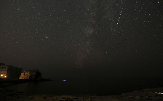 מטאור פוסע על פני שביל החלב בשמי הלילה במהלך מטר המטאורים הפרסאידים במלטה / צילום: Darrin Zammit Lupi, רויטרס
