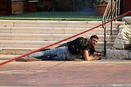 צעיר נשכב על הקרקע במהלך צבע אדום בשדרות, היום / צילום: רויטרס