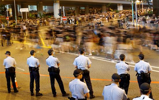 שוטרים שומרים בעד שמפגינים נגד מנהיגת הונג קונג צועדים / צילום: Tyrone Siu, רויטרס