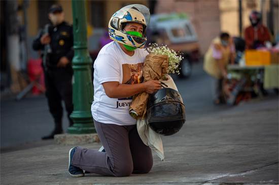 רוכבת אופנוע מתפללת על ברכיה מול כנסיה בגואטמלה בשבוע חג קדוש שכל אירועיו בוטלו בעקבות מגפת הקורונה / צילום: AP
