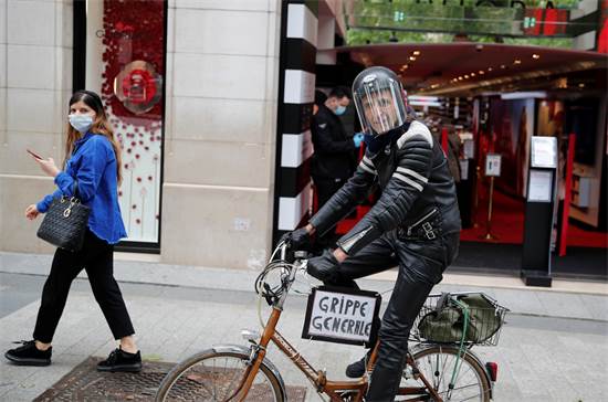 אדם עם מסכה רוכב על אופניים בשאנז אליזה בפריז לאחר ההקלות בסגר במדינה
 / צילום: Francois Mori, AP
