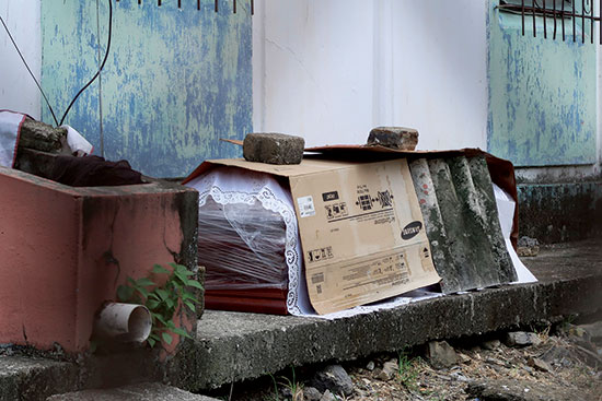 ארון קבורה ובו מת מנגיף הקורונה מחוץ לבית מגורים בגוואייאקיל / צילום: Filiberto Faustos, Associated Press