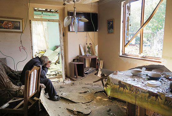 איש מבוגר יושב בדירתו שבכפר שושה בחבל נגורני קרבאך. הכפר היה אחד המוקדים להפצצות מהצד האזרי / צילום: Ismail Coskun, Associated Press