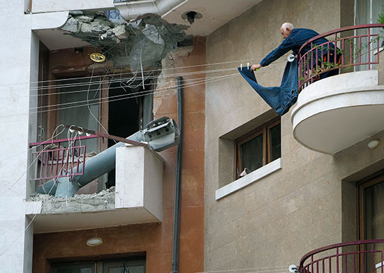 דייר באחד הבניינים שהופצצו בנגורני קרבאך מנסה להמשיך בשגרת חייו / צילום: Associated Press