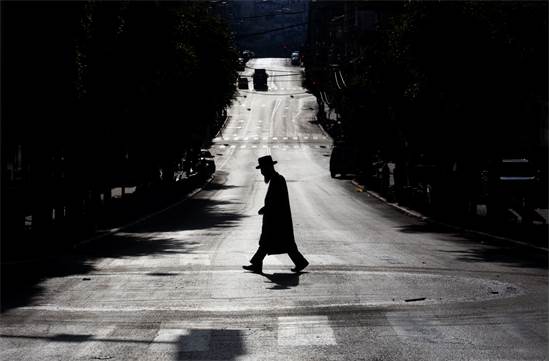 חרדי חוצה רחוב שומם במהלך הסגר בבני ברק / צילום: AP