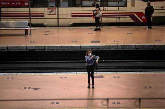 סימונים על רצפת תחנת הרכבת במדריר שמאותתים לנוסעים היכן לעמוד. הנוסעים נדרשים לשמור על מרחק זה מזה / צילום: Manu Fernandez, AP