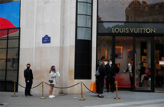 אנשים מחכים בתור כדי להיכנס לחנות היוקרה לואי ויטון בפריז / צילום: Francois Mori, AP