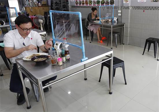 סועדים במסעדה בנגקוק, תאילנד. המסעדות הורשו להיפתח כל עוד תהיה שמירת מרחק בין הלקוחות / צילום: Sakchai Lalit, AP