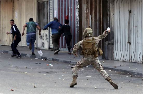 חייל זורק גז מדמיע על מפגינים בלבנון / צילום: Bilal Hussein, AP