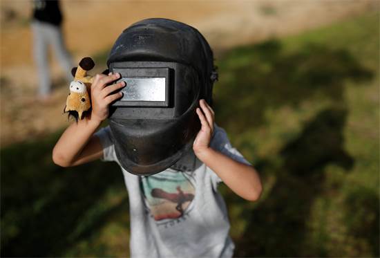 ילד בירוחם צופה בליקוי החמה החלקי. אוסר להביט בליקוי בעיניים חשופות / צילום: Amir Cohen, רויטרס