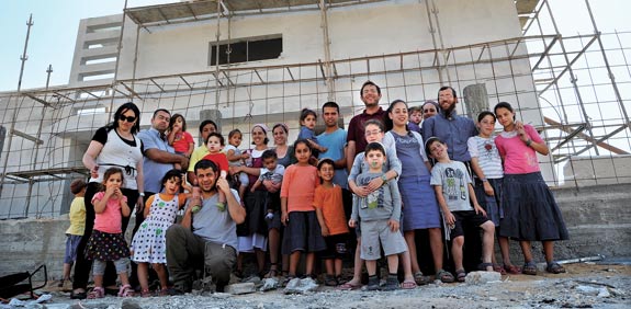 המשפחות על רקע השכונה באופקים / צילום: איל יצהר
