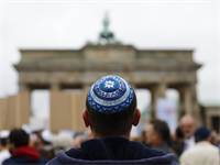 יהודי חובש כיפה עומד מול שער ברנדנבורג בברלין / צילום: Thomas Peter, רויטרס