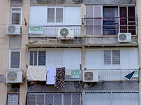 שלטים "חתמנו" תלויים על חלונות של אחד הבניינים בשכונת יפו ד' / צילום: גיא נרדי