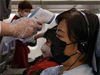 מדידת חום לנוסעת על טיסה יוצאת מסין  / צילום: Associated Press