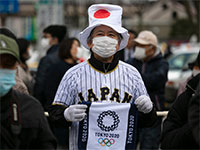 הסמל האולימפי מודפס על דגל מאולתר של אחד הצופים בלהבה האולימפית בפוקושימה, יפן / צילום: Jae C. Hong, Associated Press
