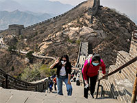 מטיילות עם מסכות בחומה הסינית / צילום: Andy Wong, Associated Press