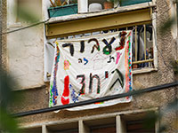 שלט עידוד שנתלה מחוץ לחלון דירה בארץ בצל הסגר / צילום: שלומי יוסף, גלובס