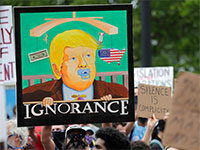 איור של טראמפ עם הכיתוב "בורות" בהפגנה במיאמי, ביום שבת / צילום: Lynne Sladky, Associated Press