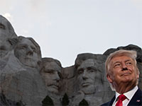 הנשיא טראמפ עומד ברקע פסלי ראשי הנשיאים של ארה"ב, של הר ראשמור המפורסם / צילום: Alex Brandon, Associated Press
