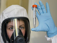מדענית במכון גמליה ברוסיה מציגה חיסון לקורונה. בשלב ראשון, רוב החברות לא ינסו לגרוף רווח מחיסונים / צילום: Alexander Zemlianichenko, Associated Press