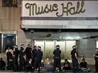 שוטרים עומדים מחוץ לאולם הופעות עם עצורים מההפגנות / צילום: Seth Wenig, AP