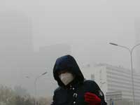 מסכה על הפנים ברחובות בייג'ין בנובמבר 2018  בגלל הזיהום / צילום : AP \ Andy Wong
