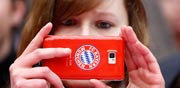 אוהדת באיירן מינכן משתמשת בטלפון הסלולרי שלה / צלם: רויטרס