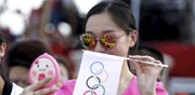 אישה סינית עושה סלפי עם דגל של הטבעות האולימפיות / צלם: רויטרס