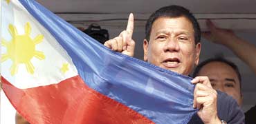 רודריגו דוטרטה ודגל הפיליפינים. המסרים הקיצוניים נופלים על אוזניים כרויות בציבור / צילום: רויטרס