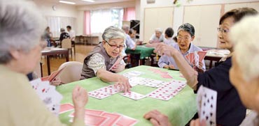 קשישים משחקים קלפים במעון / צילום: בלומברג