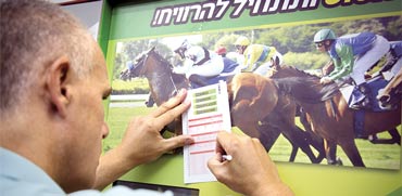 תחנה שמציעה הימורים על מרוצי סוסים / צילום: אלון רון