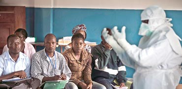 תושבים בסיירה לאון מקבלים הדרכה על ציוד הגנה מהידבקות באבולה / צילום: רויטרס