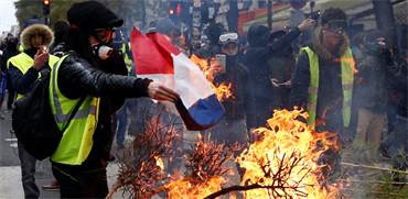 מפגין באפוד צהוב שורף את דגל צרפת בפריז / צילום: רויטרס - Stephane Mahe