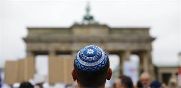 יהודי חובש כיפה עומד מול שער ברנדנבורג בברלין / צילום: Thomas Peter, רויטרס