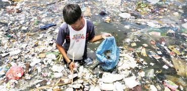 ילד מחפש פלסטיק למחזור במנילה / צילום: רויטרס