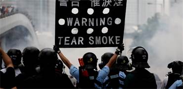 שוטר מזהיר מפגינים בעימותים בהונג קונג / צילום: Athit Perawongmetha, רויטרס