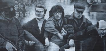 תיירים צופים בציור קיר של אירועי "בלאדי סאנדיי". הגבולות בין צפון אירלנד ואירלנד שוב במוקד המחלוקת   / צילום: Clodagh Kilcoyne, רויטרס