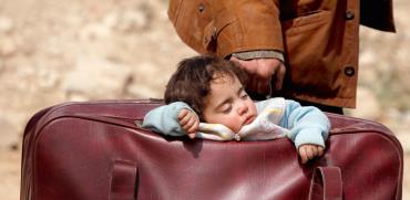 פעוט ישן במזוודה שנושא אביו בעת בריחתם מאזור קרבות בסוריה, מרץ 2018 / צילום: רויטרס - Omar Sanadiki