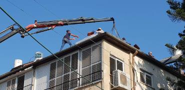 עובדים על גג בפ"ת / צילום: גיא ליברמן