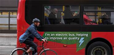 רוכב אופניים סמוך לאוטובוס חשמלי / צילום: Toby Melville, רויטרס