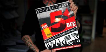 אחד מהמפגינים מחזיק שלט עם התאריך הרשמי של השביתה בפריז / צילום: Stephane Mahe, רויטרס