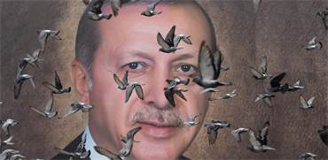 יונים עפות ליד פוסטר של נשיא טורקיה ארדואן / צילום: Goran Tomasevic, רויטרס