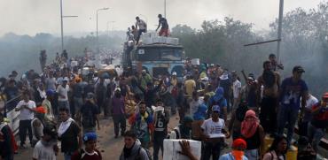אנשי אופוזיציה פורקים משאית עם סיוע הומניטרי.  / צילום: רויטרס Marco Bello