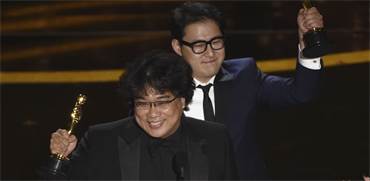 בונג ג'ון הו והאן ג'ין וון, אחרי הזכייה בפרס התסריט הטוב ביותר בטקס האוסקר / צילום: כריס פיזלו, AP