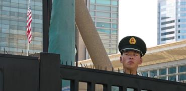 שוטר סיני בכניסה לשגרירות ארה"ב בבייג'ינג. סין מעבירה מסר בוטה למערב / צילום: Ng Han Guan, Associated Press