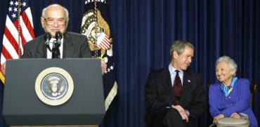 מילטון פרידמן מדבר בזמן שאשתו רוז משוחחת עם הנשיא ג’ורג’ בוש הבן / צילום: רויטרס