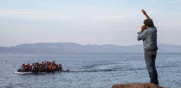 פליטים מגיעים לאי היווני לסבוס מטורקיה שנמצאת ברקע התמונה / צילום: Petros Giannakouris, Associated Press
