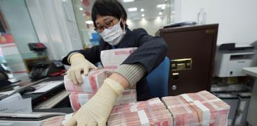 חיטוי שטרות כסף מפני נגיפים בבנק בסין  / צילום: רויטרס