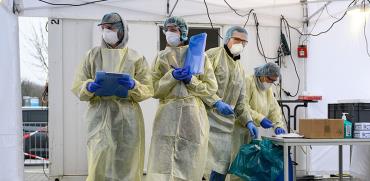 עובדי מעבדה מבצעים בדיקות קורונה בשטוטגרט, החודש / צילום: Sebastian Gollnow, Associated Press